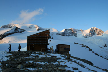 Il Rifugio Quintino Sella al tramonto, sullo sfondo il massiccio dei Lyskamm